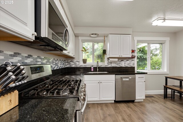 7353 SE Thiessen Rd, Milwaukie, OR 97267 - kitchen with appliances with stainless steel finishes, tasteful backsplash, white cabinetry, and plenty of natural light