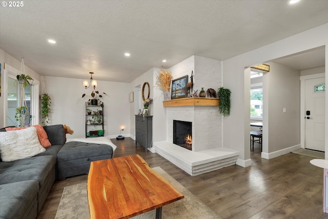 7353 SE Thiessen Rd, Milwaukie, OR 97267 - living room featuring recessed lighting, dark wood-style floors, a brick fireplace, a textured ceiling, and a chandelier