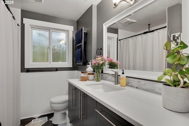 7353 SE Thiessen Rd, Milwaukie, OR 97267 - full bathroom with vanity, a textured ceiling, a wainscoted wall, and a shower with shower curtain