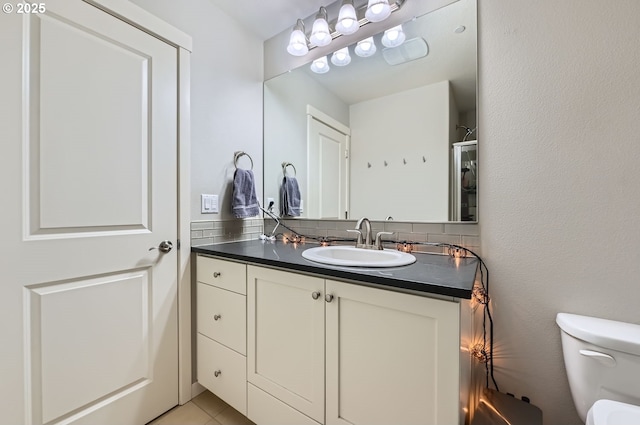 bathroom with toilet, tile patterned flooring, and vanity