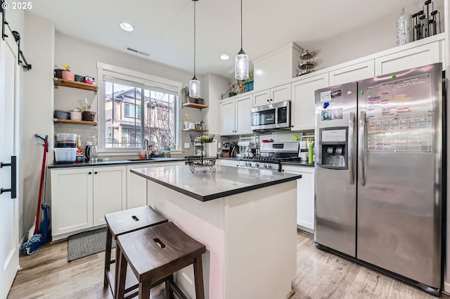 kitchen with appliances with stainless steel finishes, white cabinetry, and a breakfast bar area