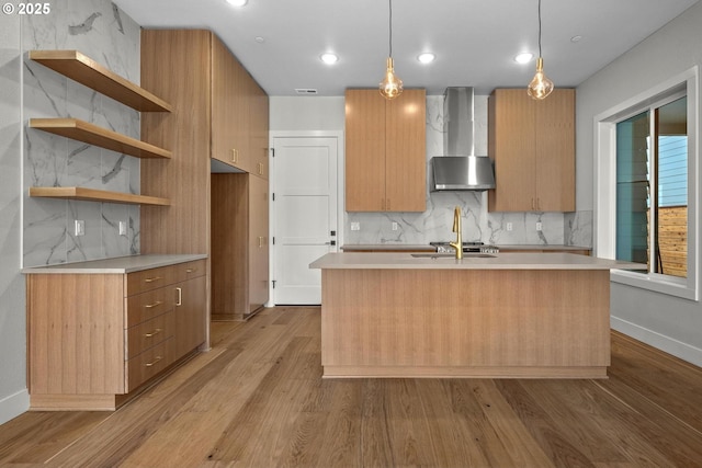 kitchen with wall chimney exhaust hood, backsplash, and decorative light fixtures