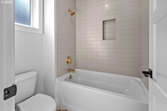 bathroom featuring tiled shower / bath and toilet