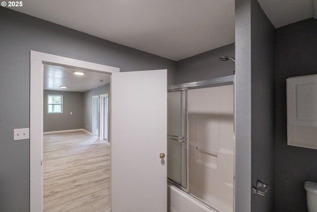 640 8th St, Astoria, OR 97103 - full bathroom featuring toilet, shower / bath combination with glass door, baseboards, and wood finished floors