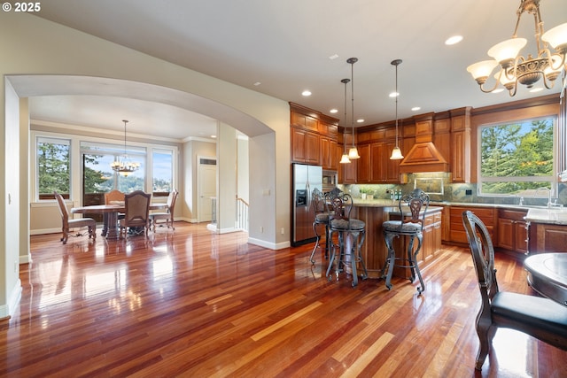 14079 SE Alta Vista Dr, Happy Valley, OR 97086 - kitchen with a chandelier, light wood-style flooring, brown cabinets, stainless steel appliances, and arched walkways