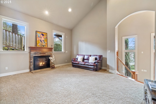 14079 SE Alta Vista Dr, Happy Valley, OR 97086 - living area with baseboards, arched walkways, a stone fireplace, high vaulted ceiling, and carpet flooring