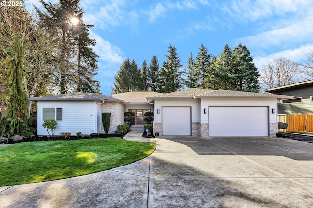 view of front facade with driveway, stone siding, an attached garage, fence, and a front lawn