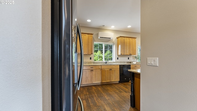87951 Blazer Ln, Bandon, OR 97411 - kitchen featuring freestanding refrigerator, black dishwasher, a wall mounted air conditioner, dark wood-type flooring, and light stone counters