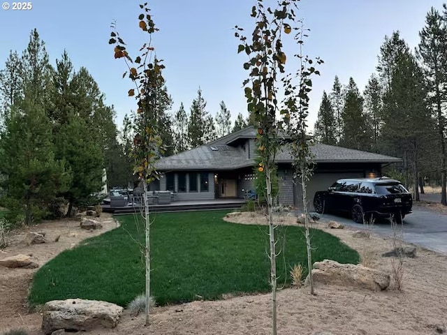 view of front of home featuring a front lawn, an attached garage, and driveway