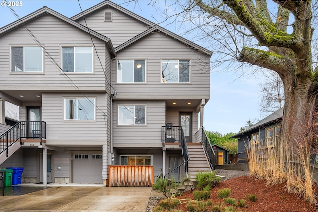 view of front of property featuring concrete driveway, stairway, and an attached garage