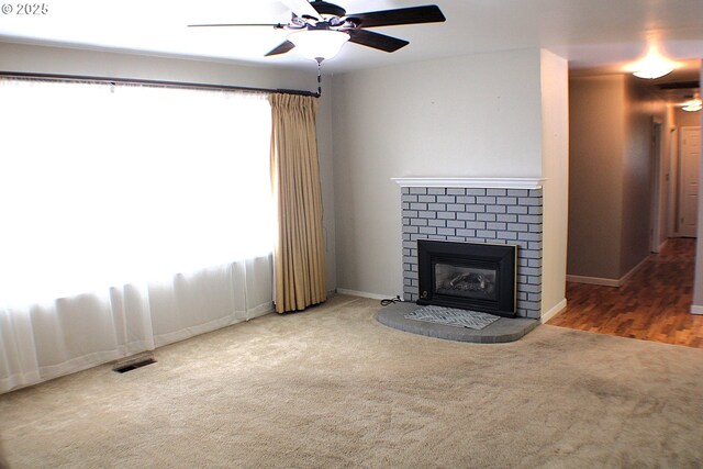 131 Mountain View Ave, Myrtle Creek, OR 97457 - unfurnished living room featuring carpet floors, a ceiling fan, and a brick fireplace