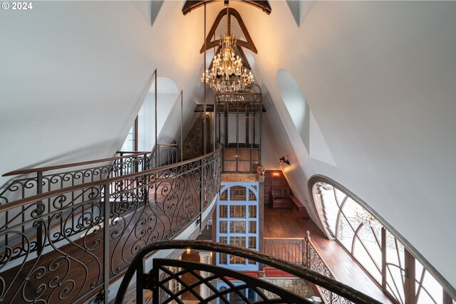26480 SW Wilken Ln, West Linn, OR 97068 - staircase featuring a high ceiling, a chandelier, wood finished floors, and arched walkways
