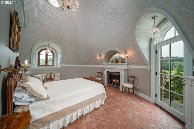 26480 SW Wilken Ln, West Linn, OR 97068 - bedroom featuring a chandelier, baseboards, and a lit fireplace