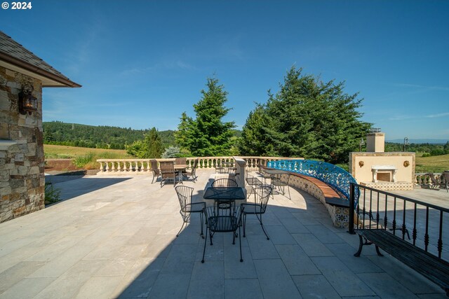 26480 SW Wilken Ln, West Linn, OR 97068 - view of patio / terrace with outdoor dining area and an outdoor stone fireplace