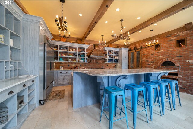 26480 SW Wilken Ln, West Linn, OR 97068 - kitchen featuring a chandelier, custom range hood, stainless steel built in fridge, brick wall, and beamed ceiling