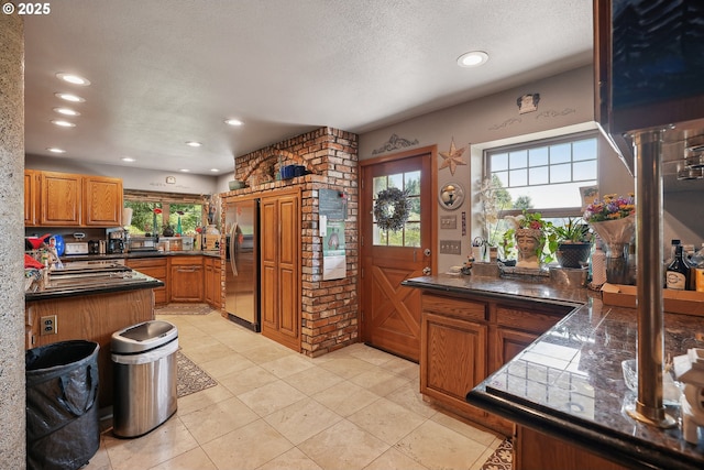 kitchen with a textured ceiling, light tile patterned floors, and stainless steel refrigerator with ice dispenser