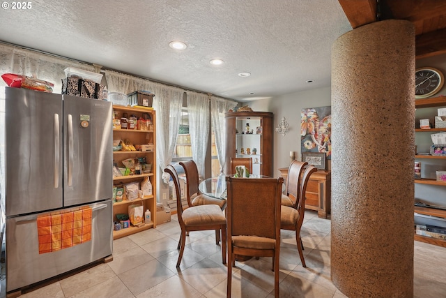 tiled dining room featuring a textured ceiling