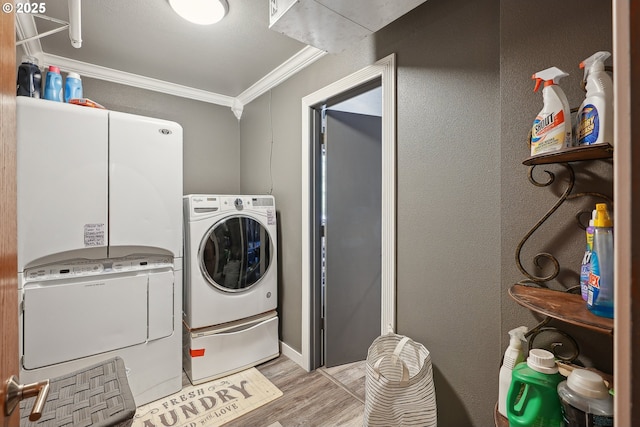 laundry area with light hardwood / wood-style flooring, washer and clothes dryer, and ornamental molding