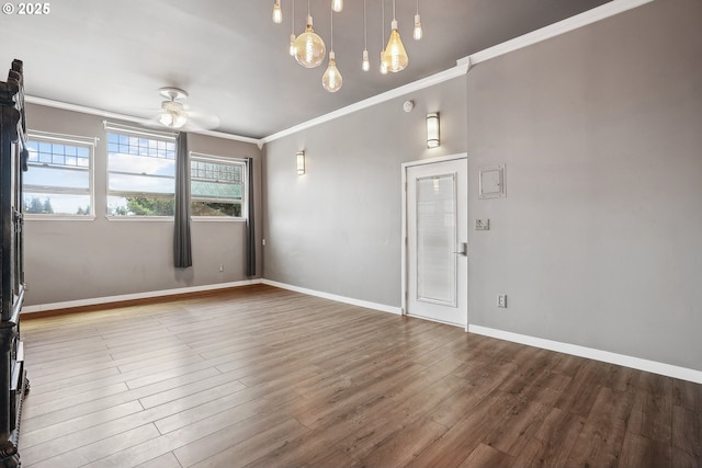 empty room featuring ceiling fan, crown molding, and hardwood / wood-style flooring