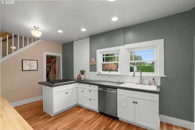 224 NE 44th Ave, Portland, OR 97213 - kitchen with stainless steel appliances, a sink, a peninsula, tasteful backsplash, and white cabinetry