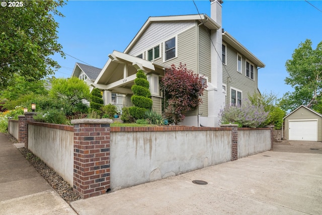 224 NE 44th Ave, Portland, OR 97213 - view of front of house featuring a chimney, a detached garage, an outbuilding, and driveway
