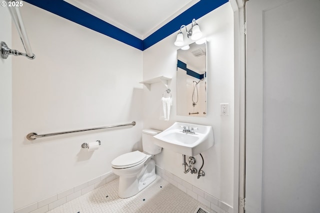 half bath featuring toilet, baseboards, and tile patterned flooring