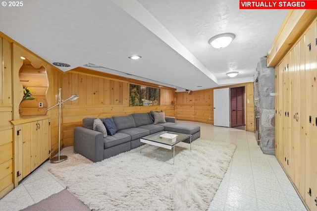living area with light floors and wooden walls