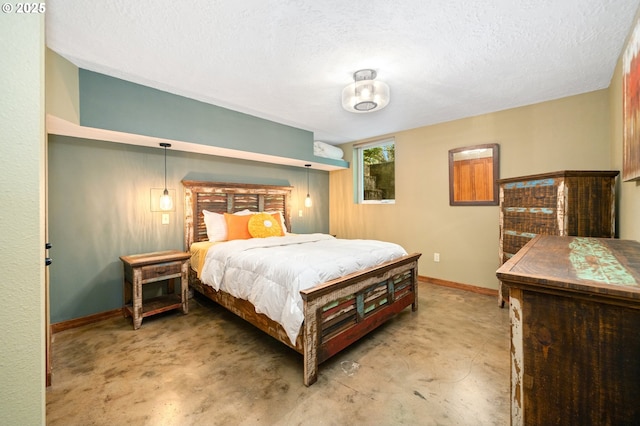 bedroom with a textured ceiling and baseboards