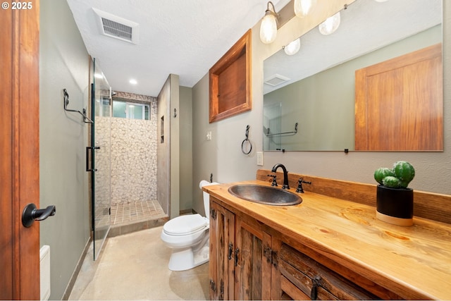 full bathroom featuring vanity, toilet, visible vents, and a shower stall