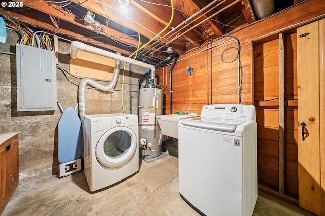 clothes washing area featuring washer and dryer, a sink, gas water heater, electric panel, and laundry area