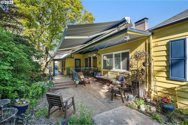 rear view of property featuring a patio and a chimney