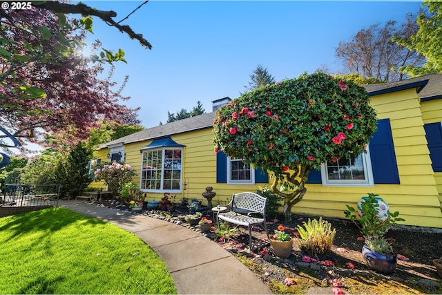 view of front of property with fence and a front lawn