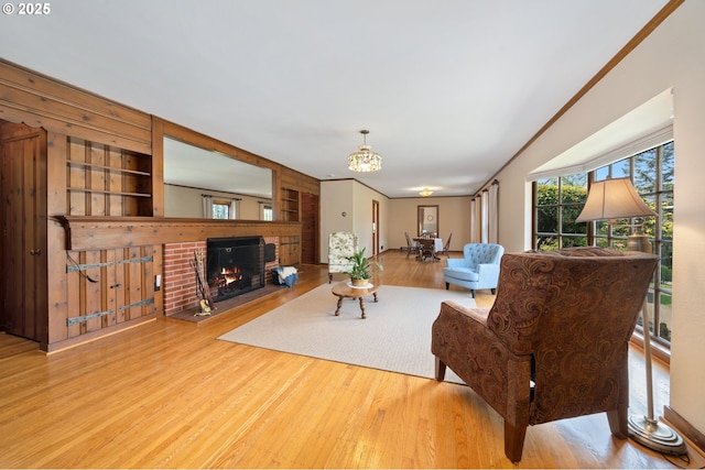 living room with a fireplace, a chandelier, and wood finished floors