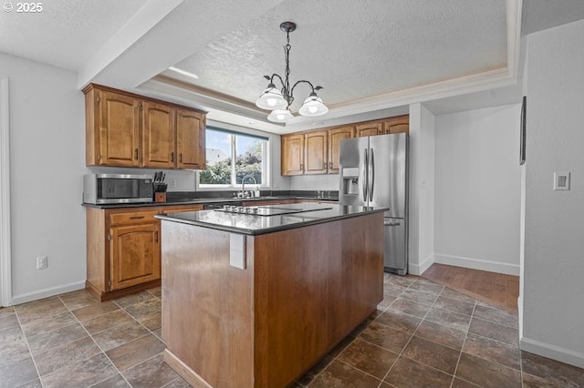 kitchen with dark countertops, appliances with stainless steel finishes, a tray ceiling, and a textured ceiling