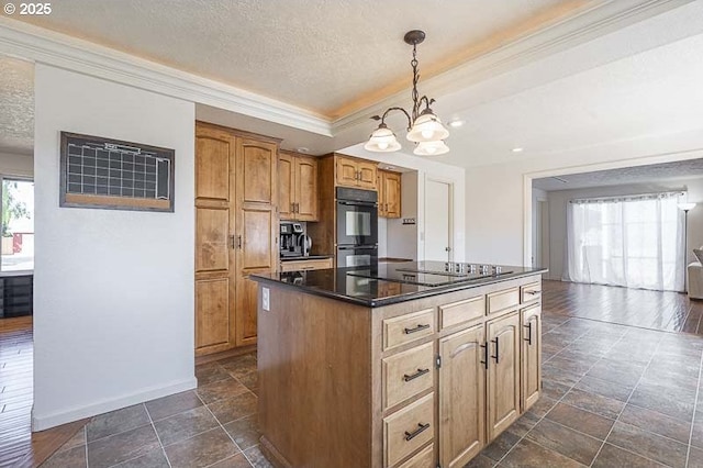 kitchen with a kitchen island, dark countertops, black appliances, a notable chandelier, and ornamental molding