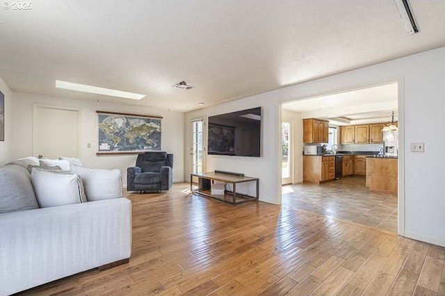 living area with baseboards and wood finished floors