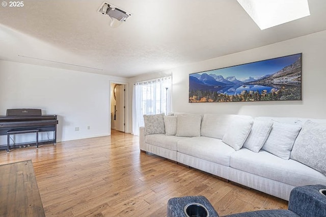 living area featuring a skylight and wood finished floors