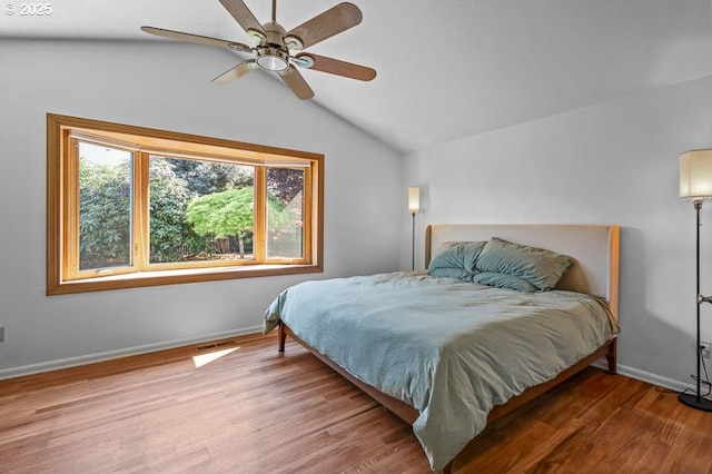 bedroom featuring baseboards, a ceiling fan, wood finished floors, and lofted ceiling