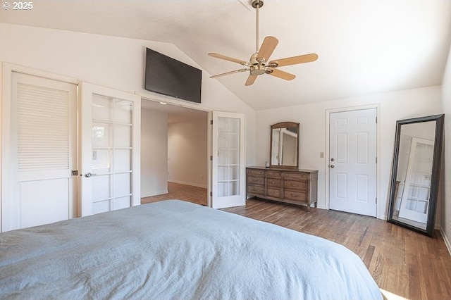 bedroom featuring ceiling fan, french doors, baseboards, wood finished floors, and lofted ceiling