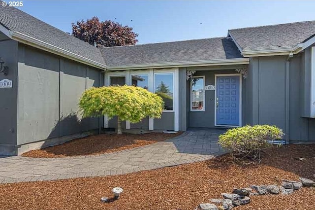 entrance to property featuring a shingled roof