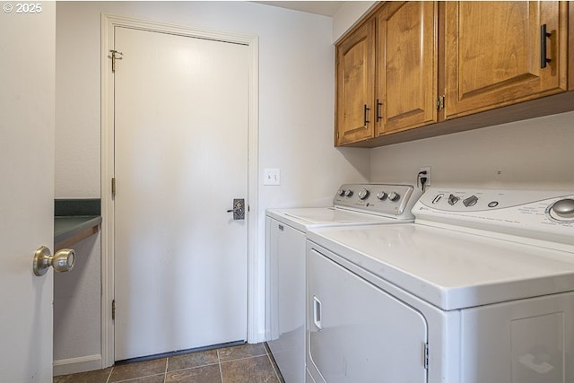 clothes washing area with baseboards, cabinet space, and washing machine and dryer