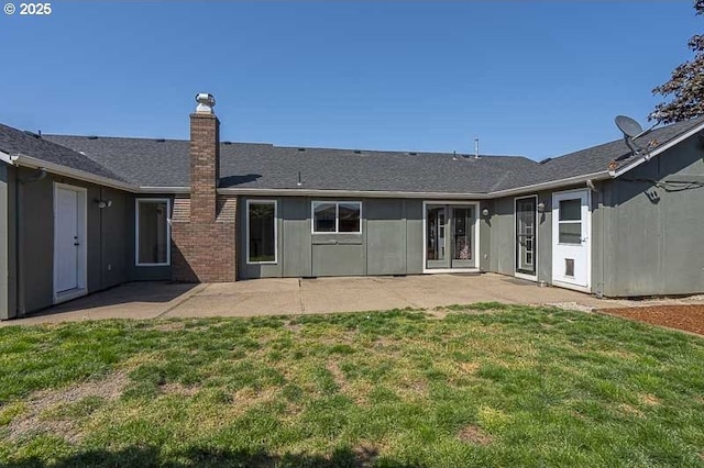 rear view of property featuring a patio area, a yard, and a chimney