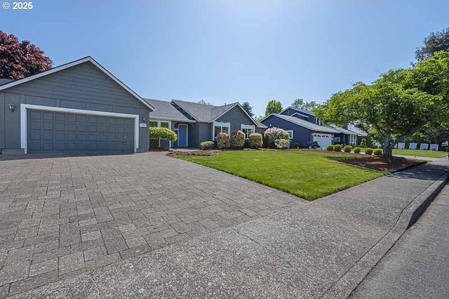ranch-style home featuring a garage, decorative driveway, and a front yard