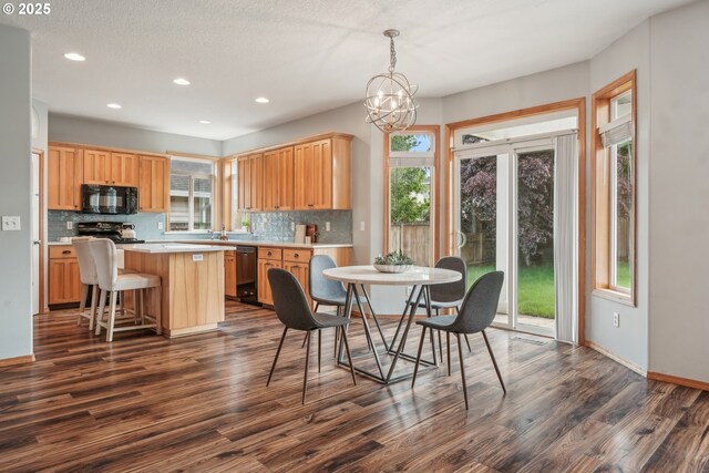 812 NW 13th Ave, Battle Ground, WA 98604 - dining room featuring dark wood-type flooring, healthy amount of natural light, recessed lighting, baseboards, and a chandelier