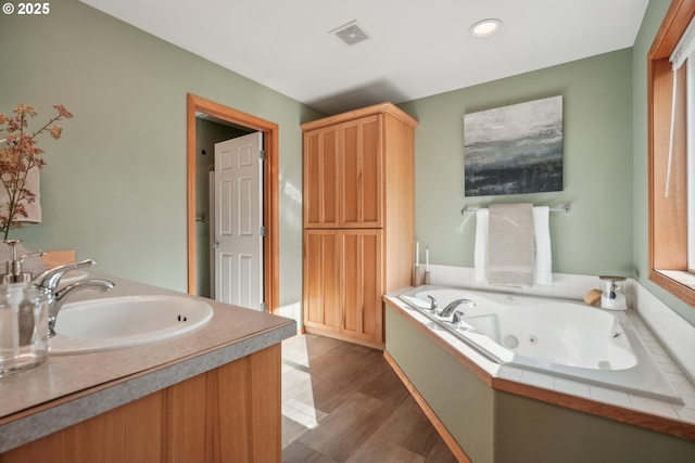 812 NW 13th Ave, Battle Ground, WA 98604 - bathroom with a tub with jets, wood finished floors, vanity, and recessed lighting