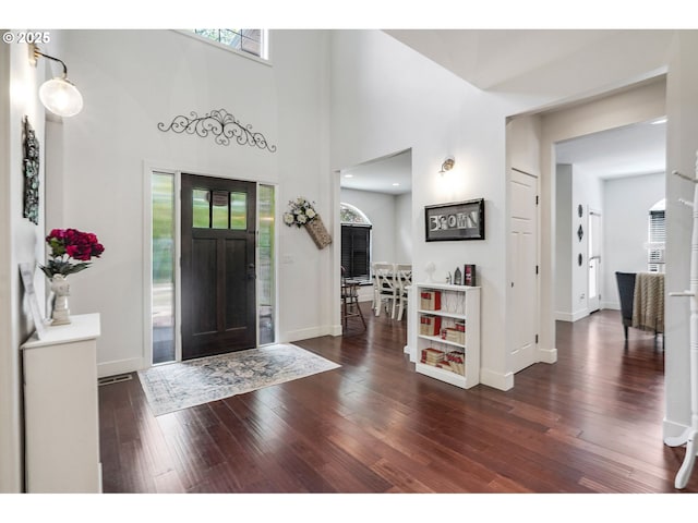 foyer entrance featuring baseboards, plenty of natural light, and hardwood / wood-style flooring