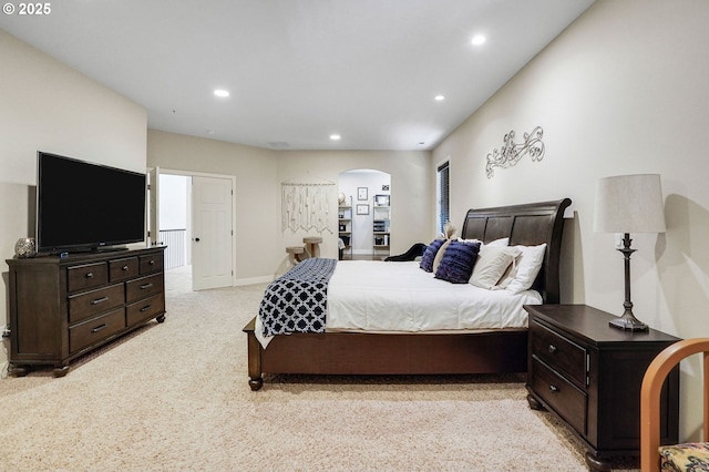 carpeted bedroom featuring recessed lighting, arched walkways, and baseboards