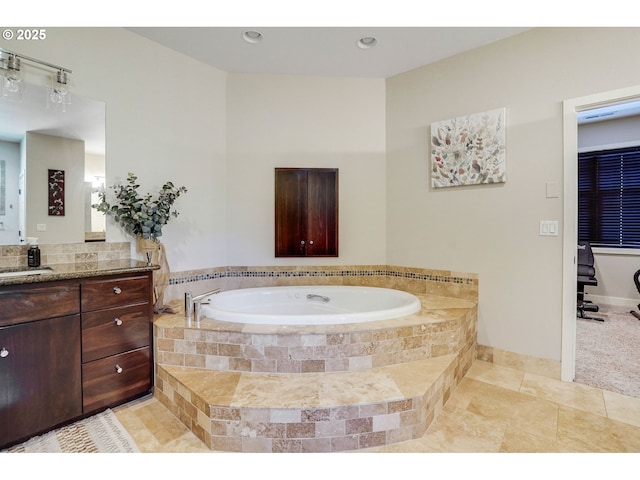 bathroom with vanity, tile patterned flooring, baseboards, and a bath