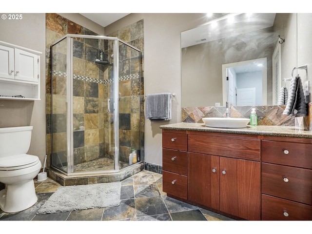 full bathroom with vanity, baseboards, a shower stall, and toilet