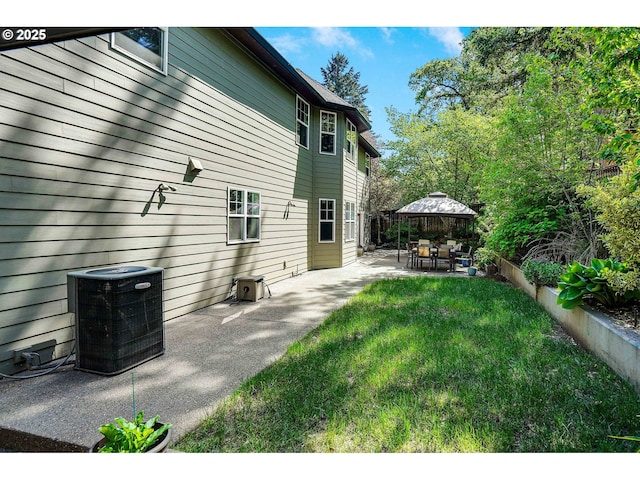 back of property with a gazebo, central AC unit, a patio area, and a yard